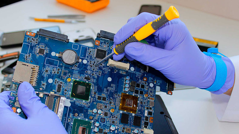 Hassas laboratuvar ortamında elektronik anakart kart onarımı yapan usta
